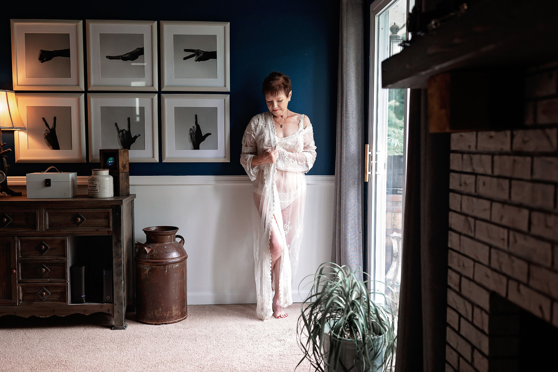 Sandra in a lace robe by the window